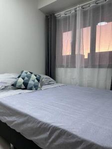 馬尼拉的住宿－Hygge Suite @ Moa complex near Naia, Ccp , Dfa，一间卧室配有一张带窗户和枕头的床