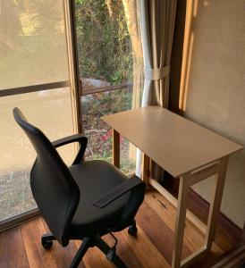 uma secretária e uma cadeira em frente a uma janela em HOSHIYAMA B extra for pets - Vacation STAY 13934v em Fujinomiya