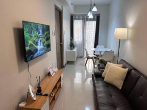 馬尼拉的住宿－Hygge Suite @ Moa complex near Naia, Ccp , Dfa，客厅配有沙发和墙上的电视