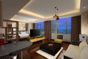 a living room with a couch and a table at Harper Malioboro Yogyakarta by ASTON in Yogyakarta
