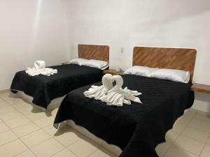duas camas com toalhas brancas por cima em REBOLLEDO IMPERIAL em San Cristóbal