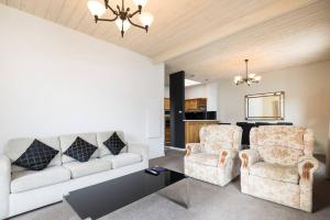 salon z 2 krzesłami i kanapą w obiekcie Hobart CBD Premium Apartment, 3 mins to waterfront w mieście Hobart