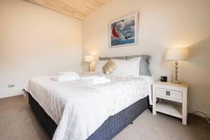 - une chambre avec un grand lit et une table de nuit dans l'établissement Hobart CBD Premium Apartment, 3 mins to waterfront, à Hobart