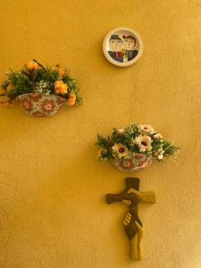 a wall with two flowers in a bowl on it at L’elegante dépendance del Barone Francesco Sala in Agrigento