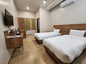 Postel nebo postele na pokoji v ubytování Hotel Gulmohar Grand