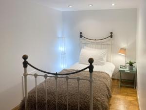 a bedroom with a bed with a metal bed frame at Cobble Cottage in Cramond