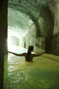 Una donna in piedi nell'acqua in una grotta di Grand Hotel Santa Domitilla a Ponza