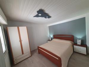 a bedroom with a bed with a bat sign on the ceiling at Matilde Holiday-home in SantʼAngelo di Brolo