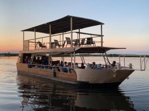 a group of people on a boat on the water at Nxabii Cottages in Kasane