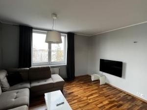 uma sala de estar com um sofá e uma televisão de ecrã plano em Do Gdyni Exclusive em Gdynia