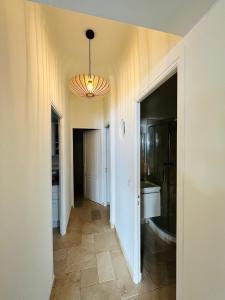 a hallway with a bathroom and a chandelier at Centre San Peire Les Issambres in Les Issambres