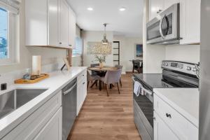 a kitchen with white cabinets and a dining table at Tower 9 #5 in Oceanside