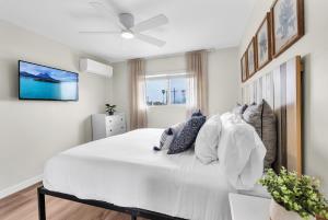 a bedroom with a large white bed with a ceiling fan at Tower 9 #5 in Oceanside