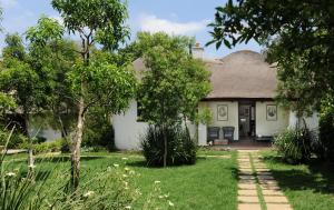 Casa blanca con techo de paja en Satyagraha House, en Johannesburgo