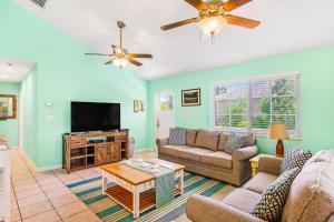 a living room with a couch and a tv at Key Lime Time in Cudjoe Key