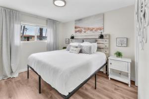 a white bedroom with a large bed and a window at Tower 9 #4 in Oceanside