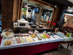 una mesa con muchos alimentos diferentes en ella en Hotel Livia, en Tirana