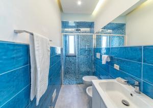 ein blaues Badezimmer mit WC und Waschbecken in der Unterkunft Casa Yucca in Ischia