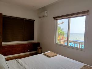 a bedroom with a large window with a view of the ocean at Nahas Beach Resort 