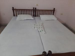 a white bed with two pillows on top of it at Hotel Peacock in Kovalam