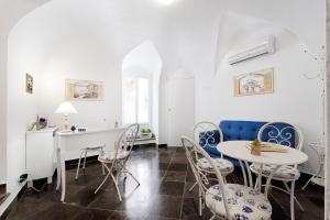 ラグーザにあるIl Quartino Di Palazzo Maggioreの白い壁のダイニングルーム(青い椅子、テーブル付)