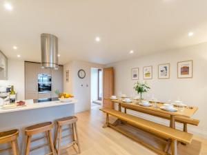 a kitchen and dining room with a table and chairs at Haybale Barn in Chatton