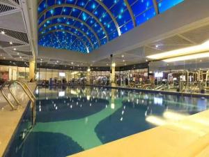 a large swimming pool in a building with a ceiling at Shenzhen Shuidu Holiday Hotel, North Railway Station in Shenzhen