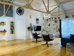 a living room with a clock on the wall at Loft Évasion - Loft lumineux et climatisé entre Montpellier et les plages - 2 chambres - Parking - Tram in Lattes