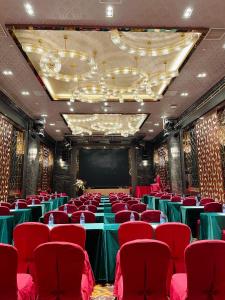 a conference room with red chairs and a screen at Shenzhen Shuidu Holiday Hotel, North Railway Station in Shenzhen