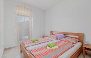 a bedroom with two beds with pillows and a window at Nice Apartment In Ribarica - Karlobag in Matić Podi