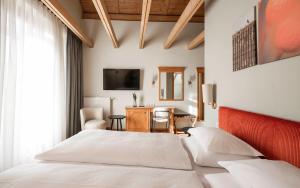 a bedroom with a bed with a red headboard at Boutique Hotel Pachers in Bressanone