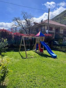 a playground with a slide in a yard at Villa Somma Apartments in Pimonte