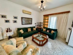 a living room with green couches and a coffee table at Villa Vaso in Yimnón