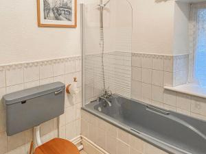 a bathroom with a tub and a toilet and a sink at New Cottage in Penmaenpool