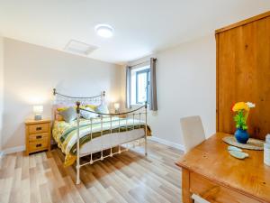 1 dormitorio con 1 cama y suelo de madera en The Tractor Shed en Matfield