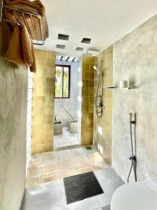 ein Bad mit einer Dusche und einem WC in der Unterkunft Isana Beach House in Tangalle