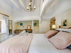 a large bedroom with two beds and a chandelier at Honeysuckle Cottage in Axminster