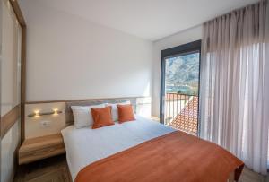 a bedroom with a bed and a large window at Marea DeLuxe Apartments in Kotor