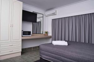 um quarto de hotel com uma cama e um micro-ondas em Leeton Centre Motel em Leeton