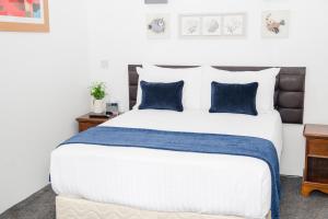 a bedroom with a large bed with blue pillows at Hamlet Hotels Maidstone in Maidstone