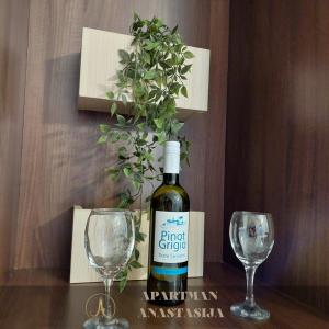 a bottle of wine and two wine glasses on a table at Apartman Anastasija Vrnjačka Banja in Vrnjačka Banja