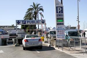 ein Auto, das auf einem Parkplatz mit einem Straßenschild parkt in der Unterkunft Hôtel Alizé in Cannes