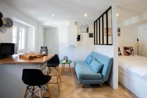 a room with a bed and a blue chair and a desk at Mystery emplacement 1er in Annecy