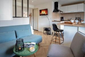 uma sala de estar com um sofá azul e uma cozinha em Mystery emplacement 1er em Annecy