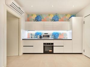 a kitchen with white cabinets and a microwave at ApartmentsArena - Residenza Dei Doganieri - Verona in Verona