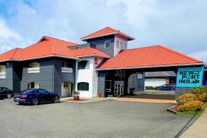 a hotel with a car parked in a parking lot at Newport Inn By OYO - Hwy 101 in Newport