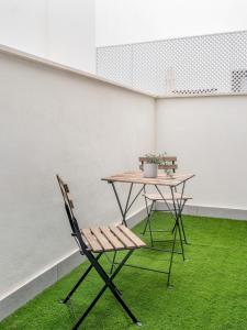 una mesa y una silla con césped en una habitación en Modern with swimming pool- 2Bd 2Bth- Triana en Sevilla
