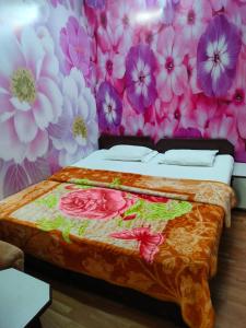 a bedroom with a bed with flowers on the wall at Hotel Raj in Agra