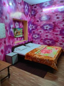 una camera da letto con una parete di fiori rosa di Hotel Raj ad Agra