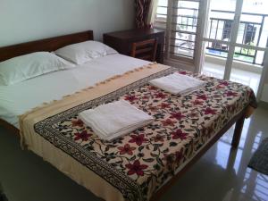 a bed with two folded towels on top of it at Nathans Holiday Home in Cochin